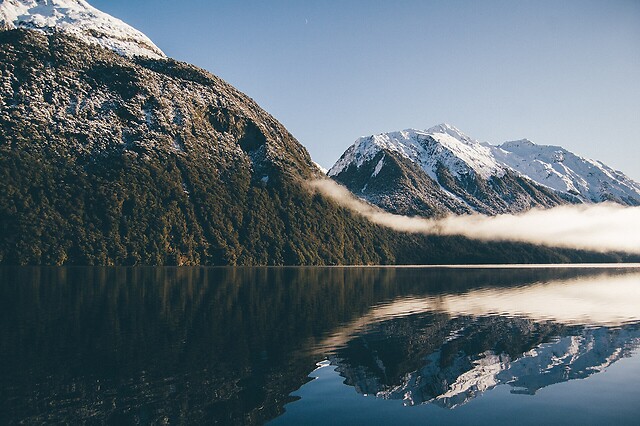 a snowy mountain over a lake